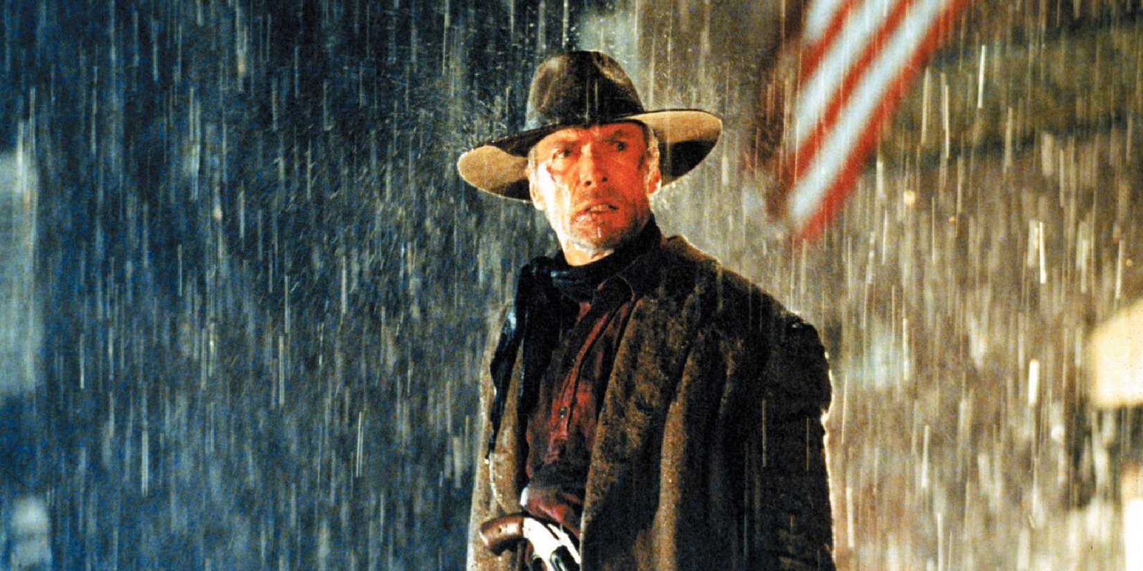 Clint Eastwood as William Munny, standing in the rain, in Unforgiven.