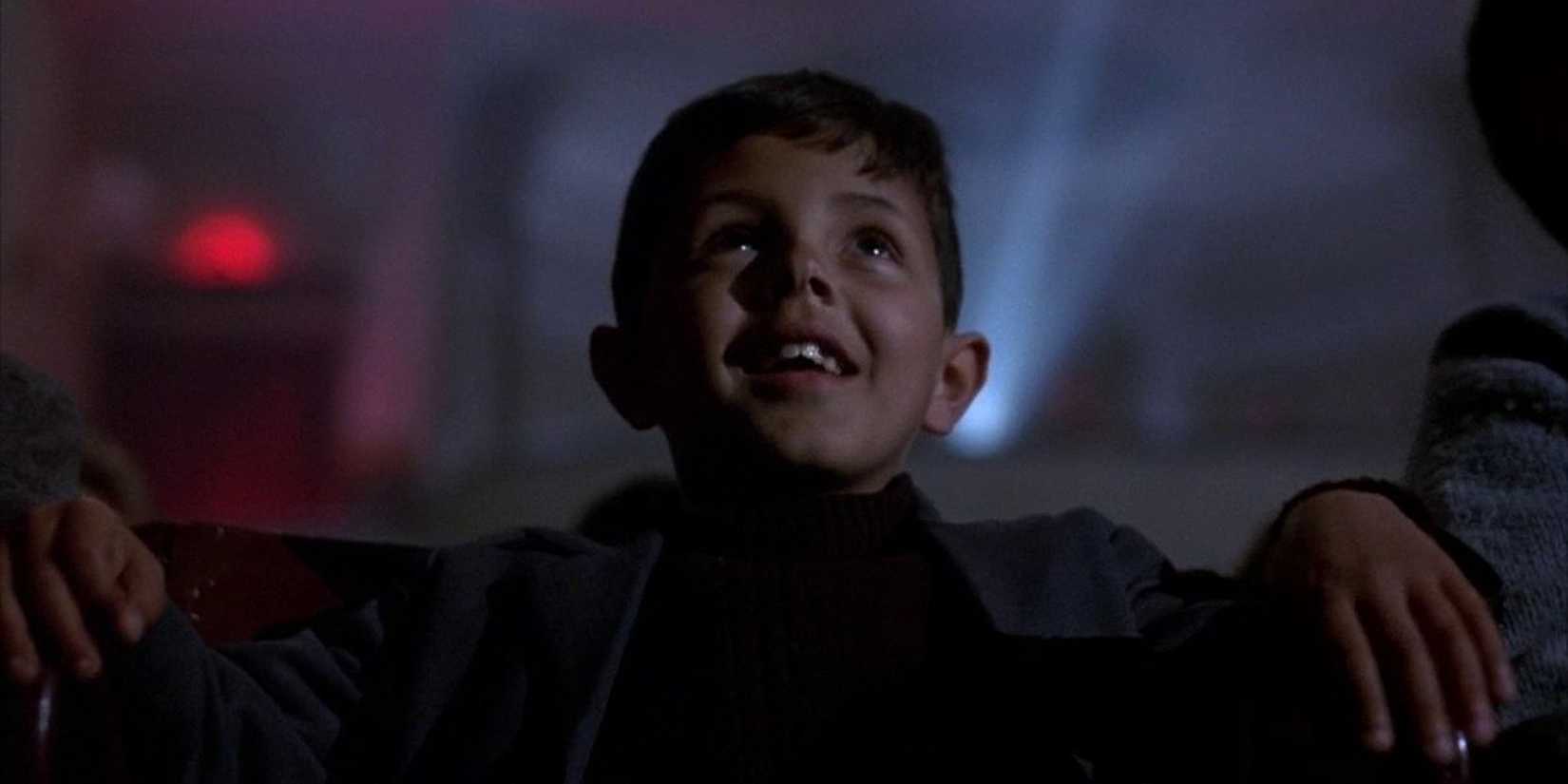Young Totò watching a movie in the theater in Cinema Paradiso.