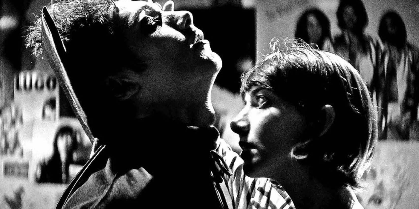 Black and white image of a teenage girl smelling the neck of a teenage boy dressed s a vampire.