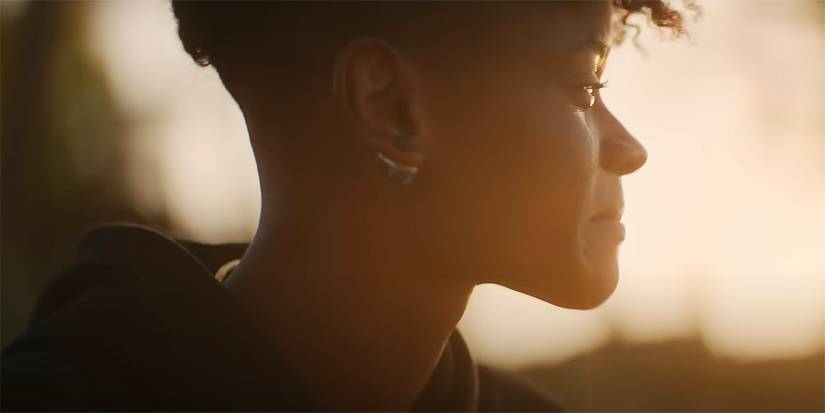 Letitia Wright as Shuri full of emotion looking into the sunset at the end of Black Panther Wakanda Forever.