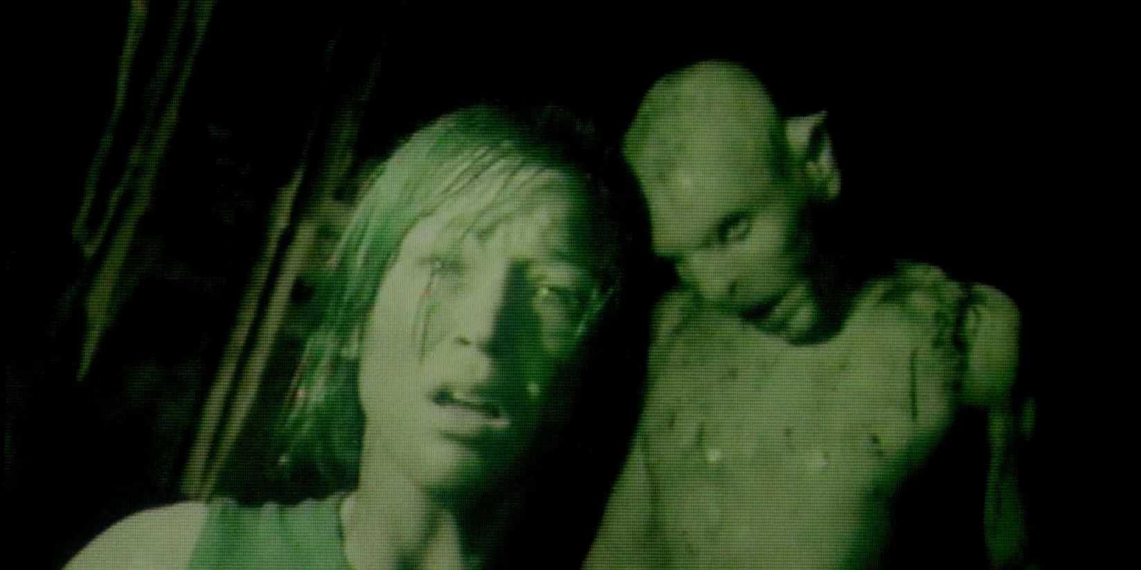 A crawler standing behind a woman in The Descent.