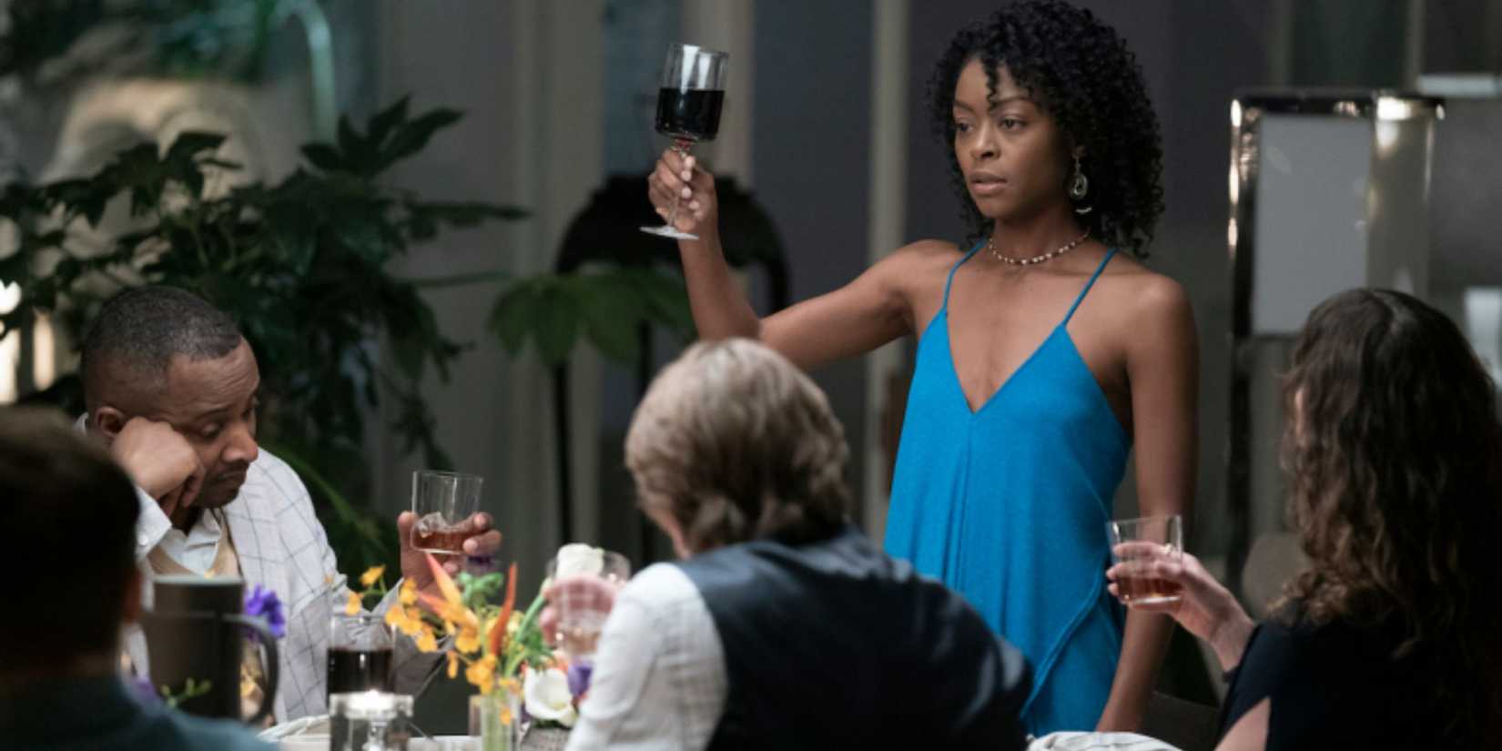 Danielle Deadwyler as Miranda raising a glass of wine at a table in Station Eleven