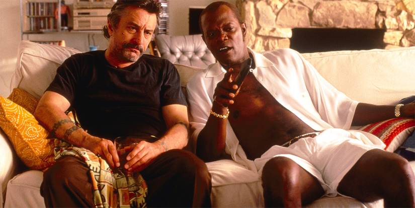 Robert De Niro and Samuel L. Jackson talking while sitting on a couch in Jackie Brown (1997).