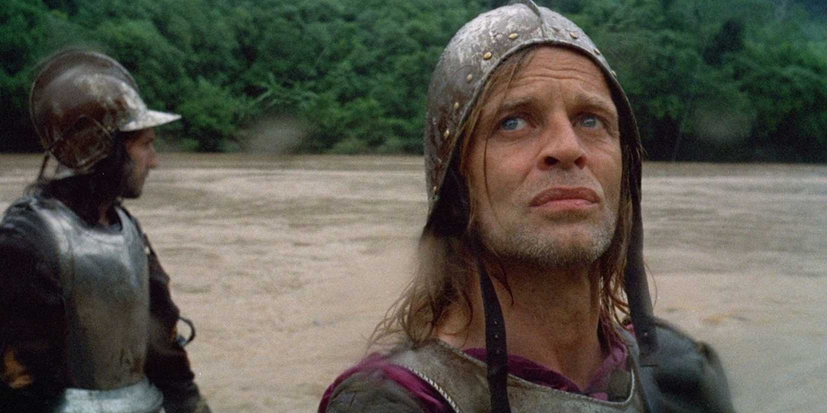 man with medieval armor in front of a dirty river