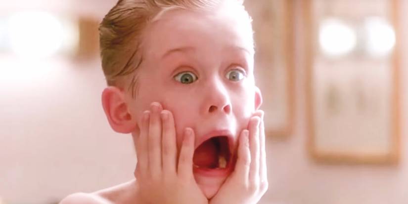 Kevin (Macaulay Culkin) holding his hands to his face and screaming in front of the mirror in Home Alone.
