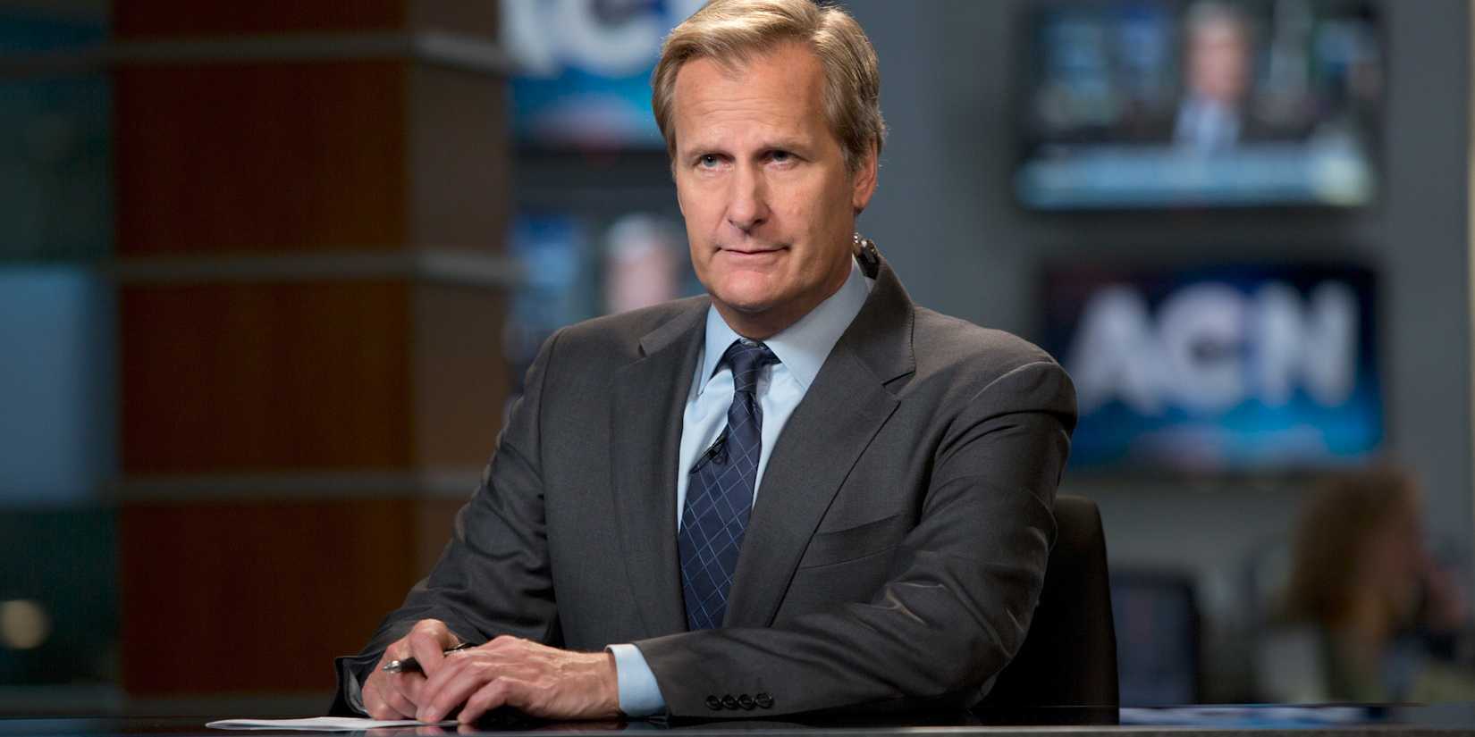 Jeff Daniels as Will McAvoy sitting at the anchor desk in The Newsroom