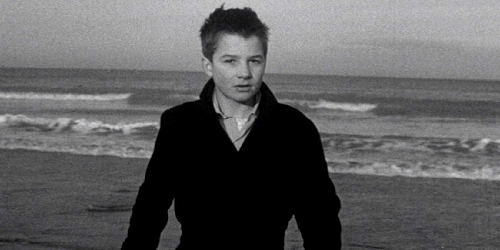 Žans Pjērs Leo kā Antuāns Donels stāv pludmalē filmā The 400 Blows.