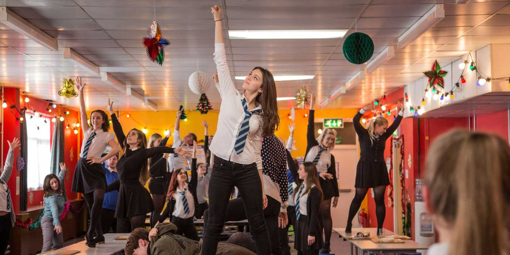 Anna dan teman-teman sekelasnya berdiri di atas meja di ruang kelas sebagai bagian dari nomor musik di Anna dan Kiamat.