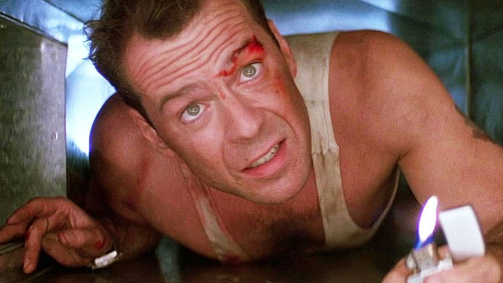 Bruce Willis as John McClane holding a lighter while crawling through an air duct in Die Hard