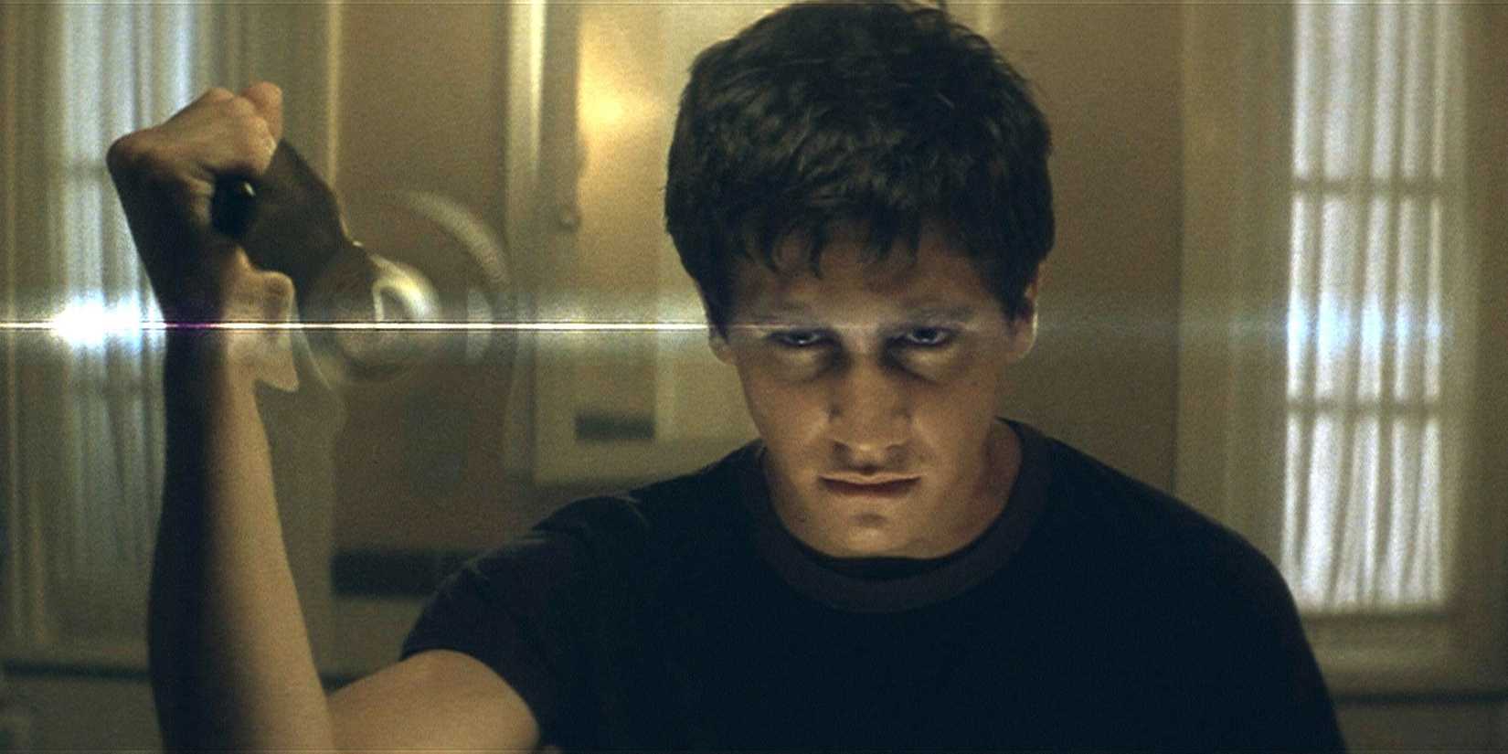 Jake Gyllenhaal as Donnie Darko looking in the mirror with a serious expression.