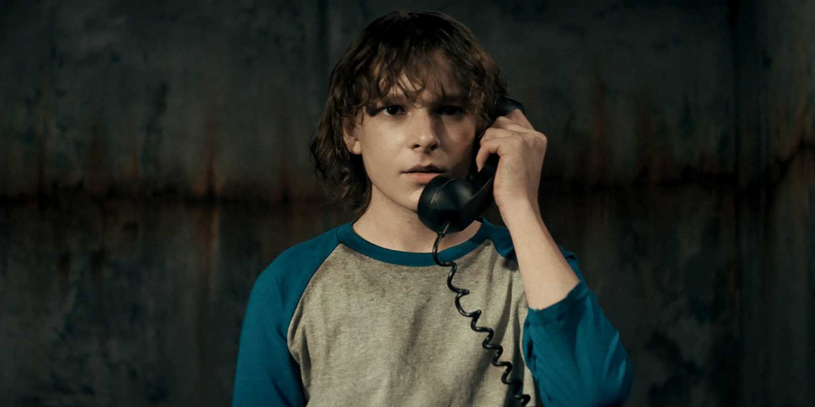 Finney holding The Black Phone up to his ear