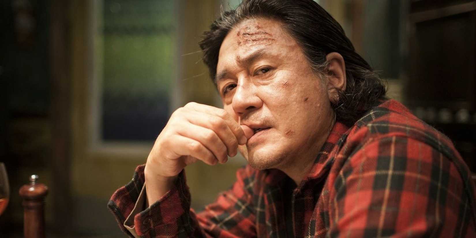 Kyng-Chul sitting down and looking intensily to his left in 'I Saw the Devil'