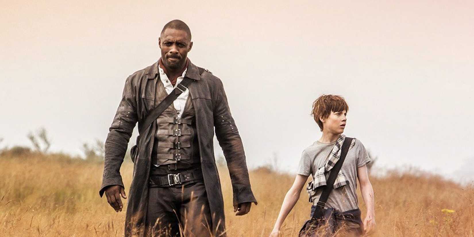 Idris Elba and Tom Taylor walking in a field in 'The Dark Tower'