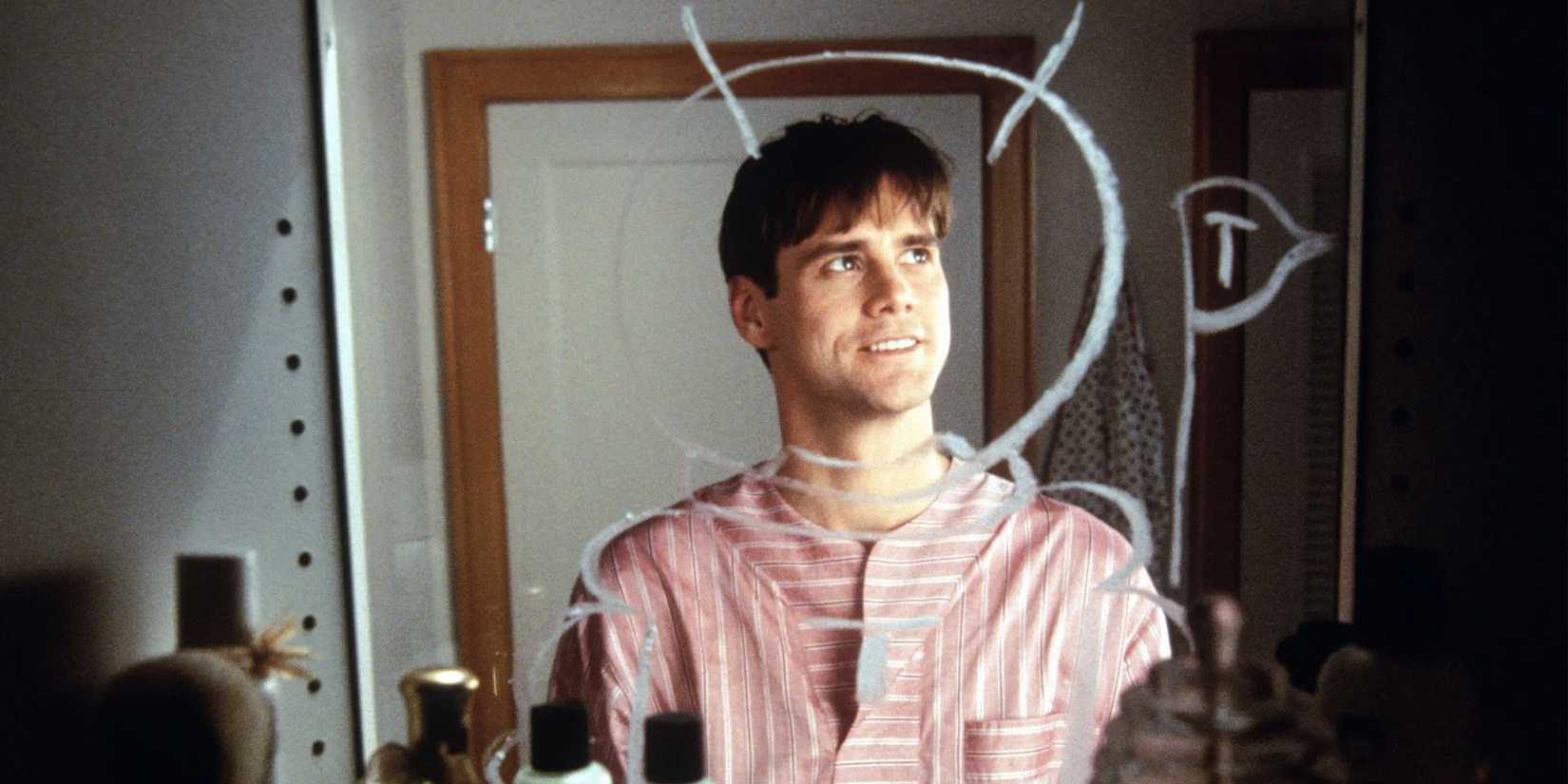 Truman Burband standing in front of a mirror smiling in 'The Truman Show'