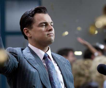 Jordan Belfort, standing amid a celebration at his office while confetti falls