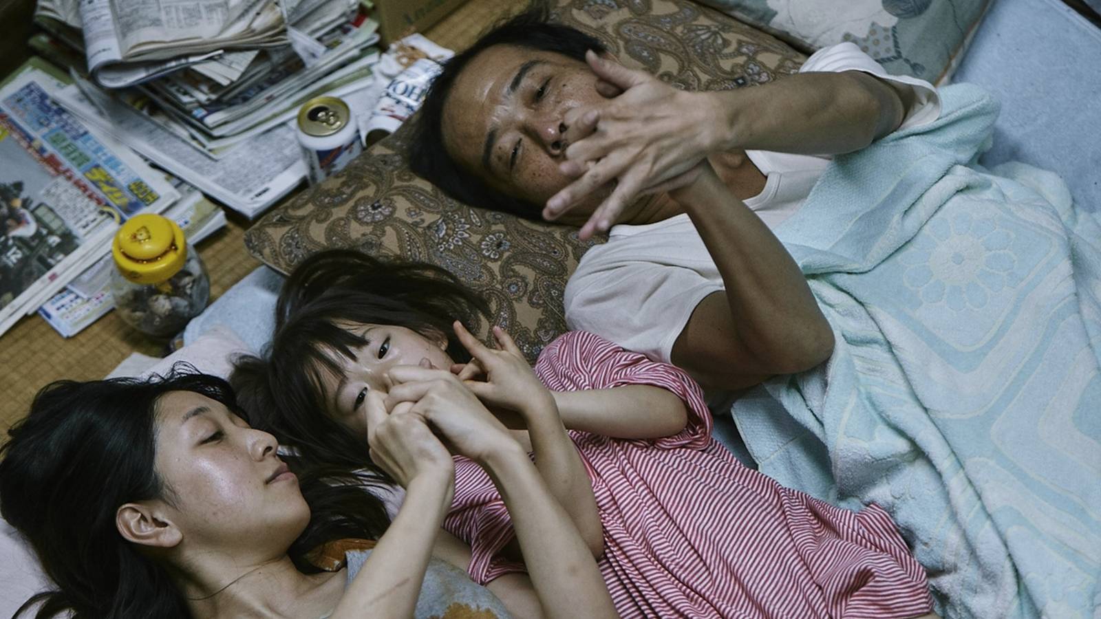 Lily Franky, Sakura Andô, and Miyu Sasaki lying on the floor in 'Shoplifters'