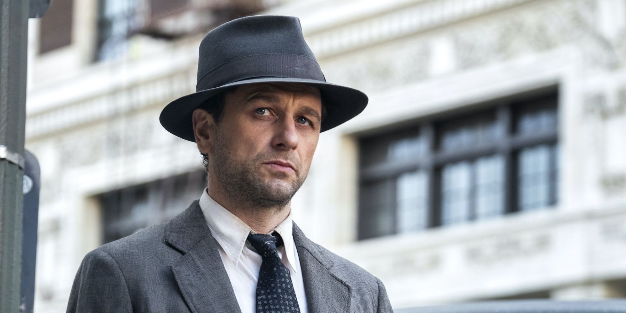Perry Mason on the street looking to the distance.
