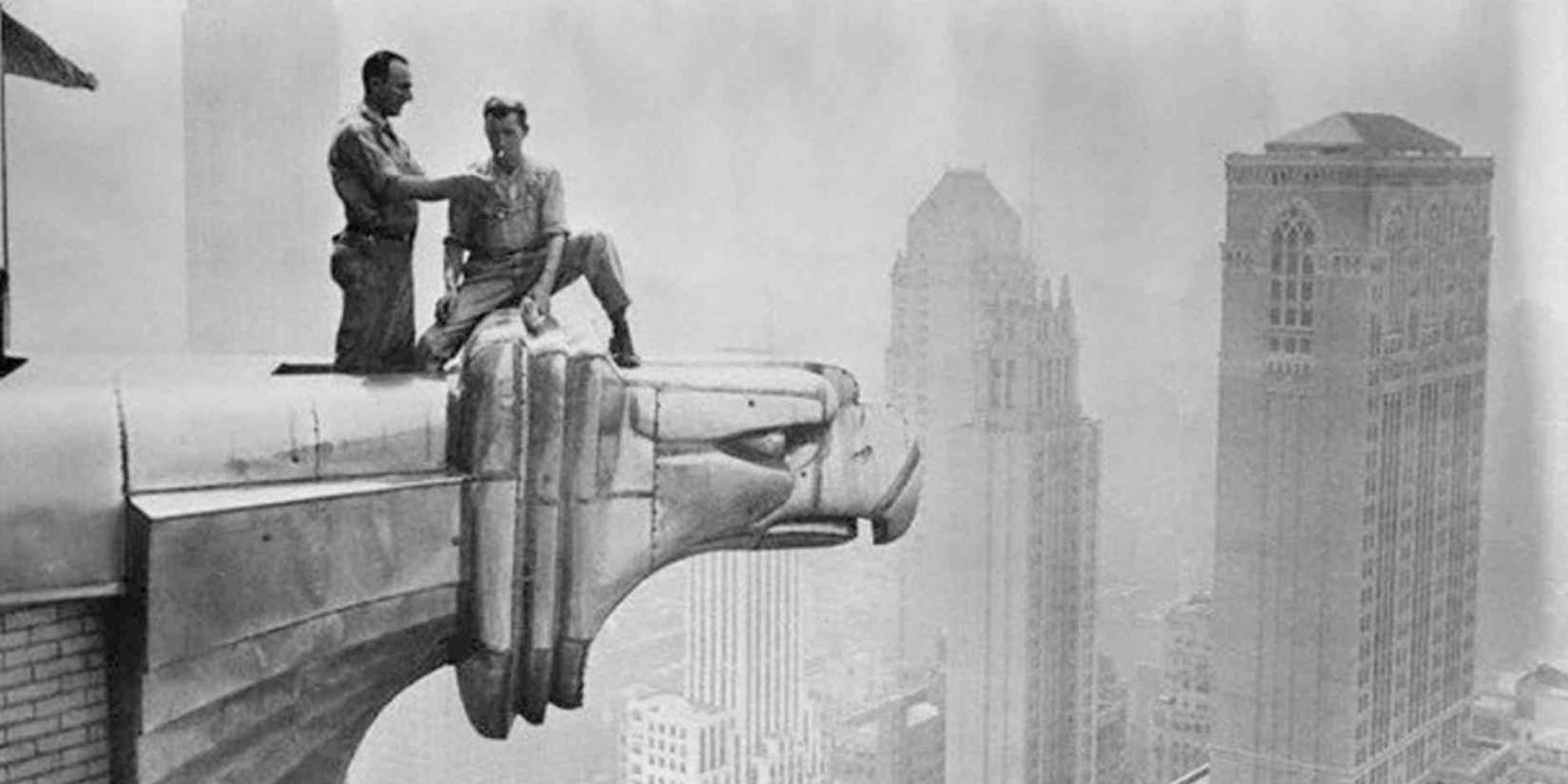 Two men on a gargoyle atop a skylight in Metropolis