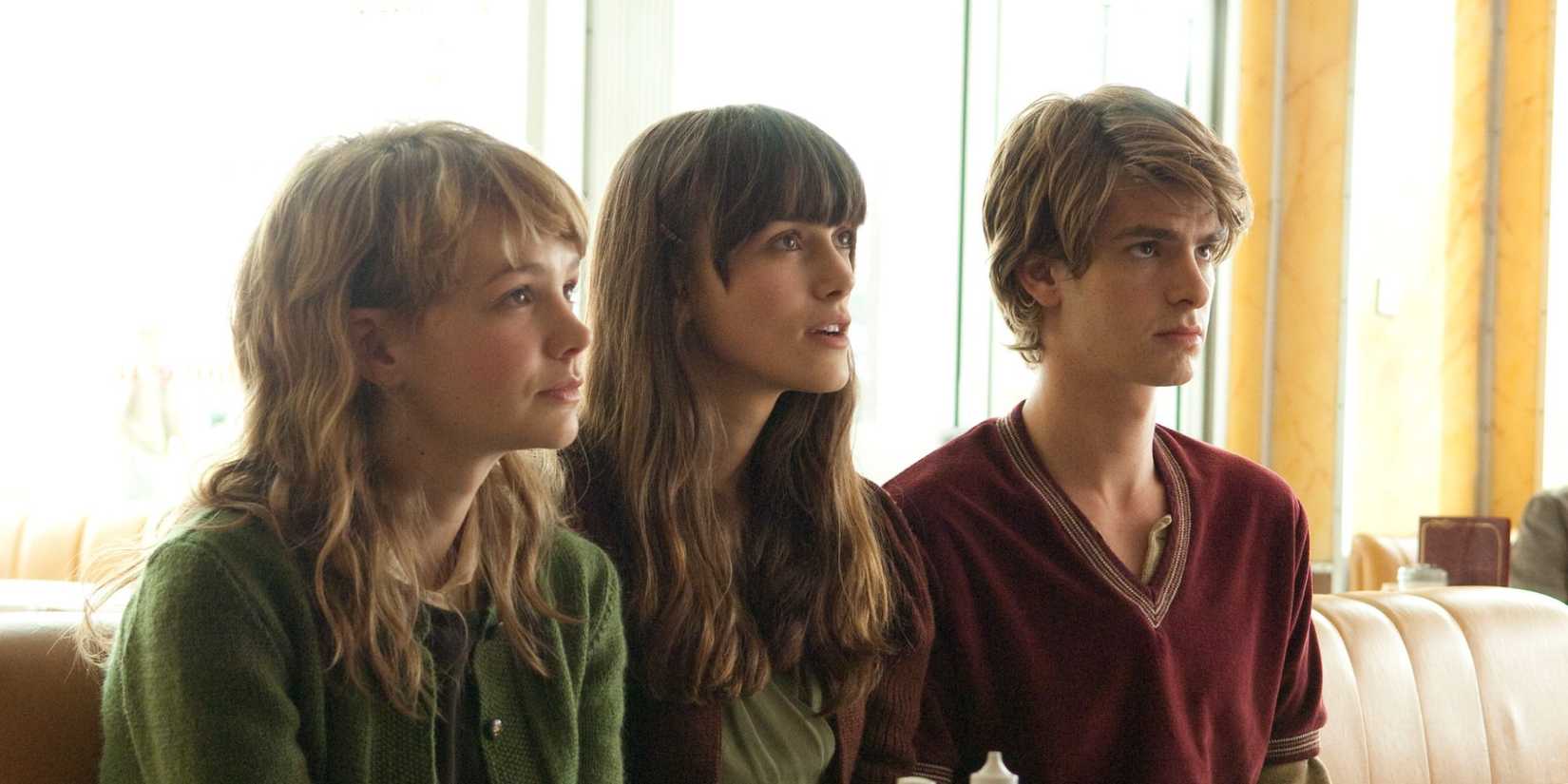 Kathy, Tommy, and Ruth sitting next to each other looking ahead in Never Let Me Go