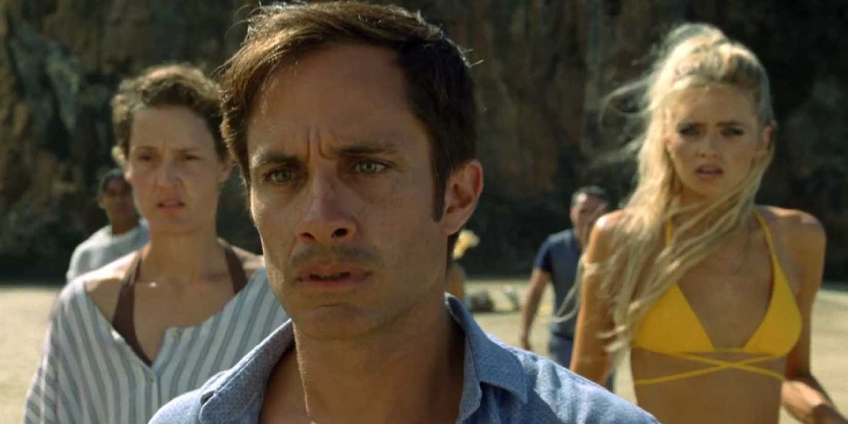 Guy Cappa and two women behind him looking ahead with shocked expressions in Old - 2021