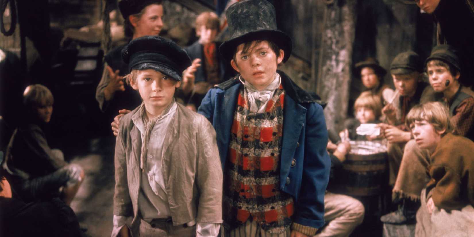 Oliver (Mark Lester) and The Artful Dodger (Jack Wild) with hopeful expressions in the film Oliver.