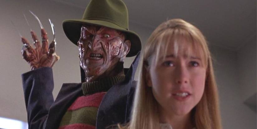 Robert Englund standing behind a girl with his arm in the air about to strike in New Nightmare