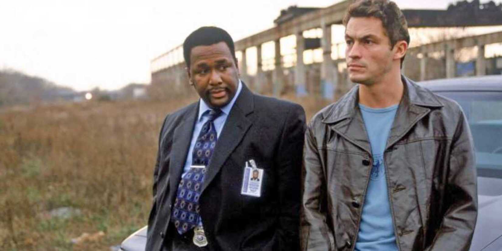 Jimmy McNulty (Dominic West) and Bunk Moreland (Wendell Pierce) leaning against a car and looking pensive in 'The Wire’