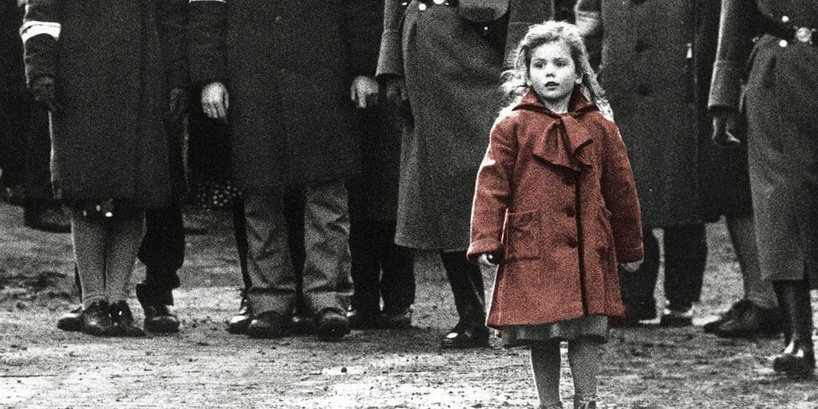 A little girl wearing a red coat walks alone in Schindler's List