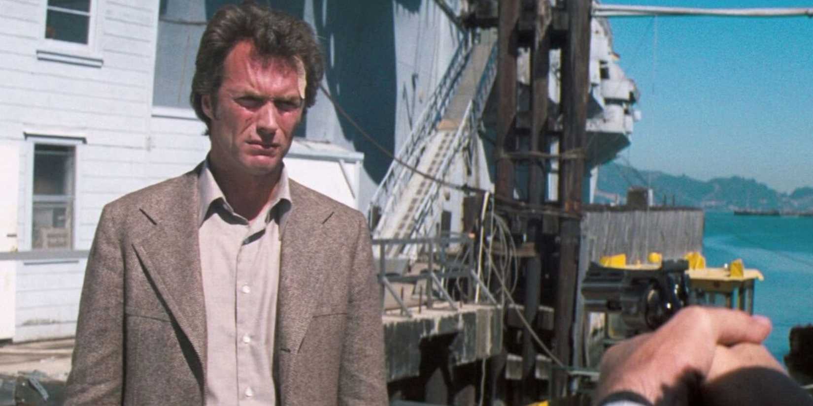 Clint Eastwood as Harry Callahan standing at a marina looking at someone off screen in Magnum Force.