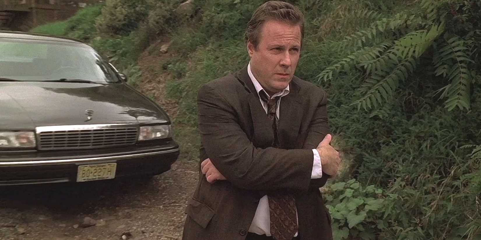 John Heard standing with his arms folded across him in The Sopranos