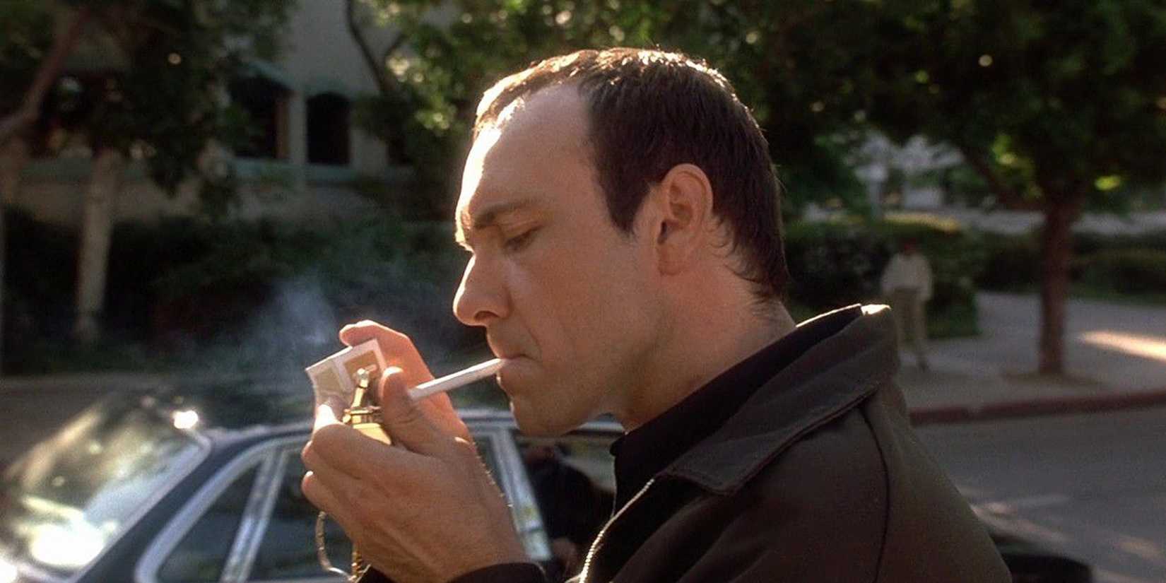 Verbal Kint smoking a cigarette in front of a parked car in The Usual Suspects.