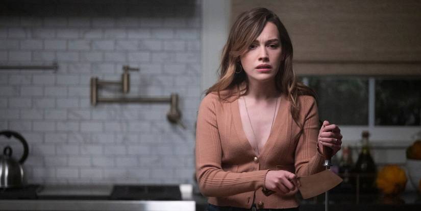 Victoria Pedretti as Love Quinn looking upset as she sharpens her knife in the 'You' Season 3 finale.