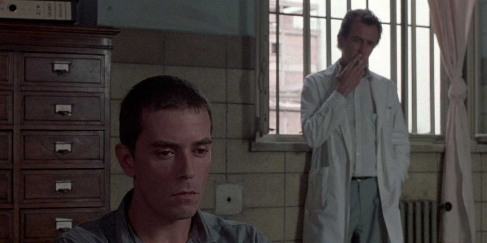 A doctor smoking and looking at a young man in Man Facing Southeast