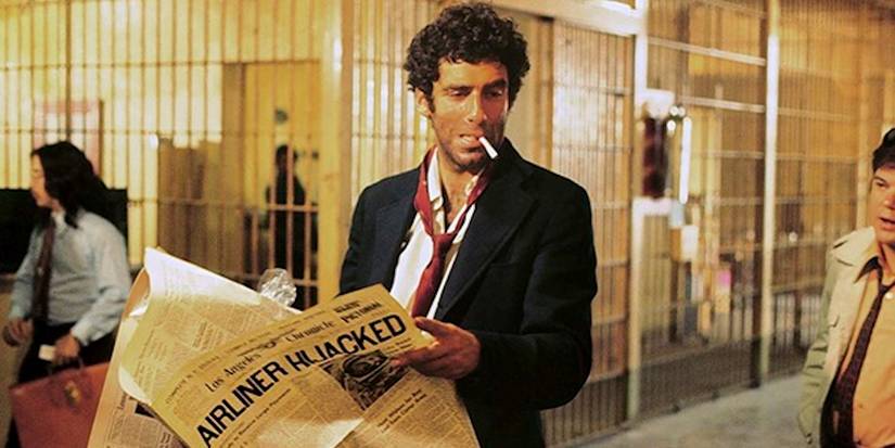 Philip Marlowe smoking while holding a newspaper in prison in The Long Goodbye