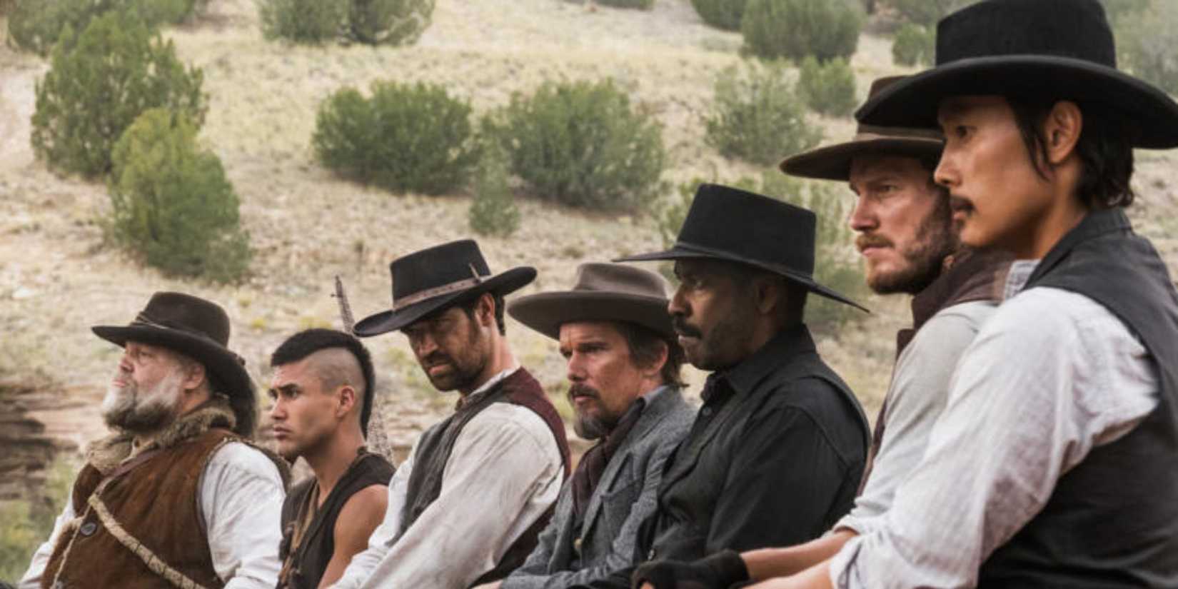 The cast look forward into the distance outside on a western landscape in The Magnificent Seven, 2016.