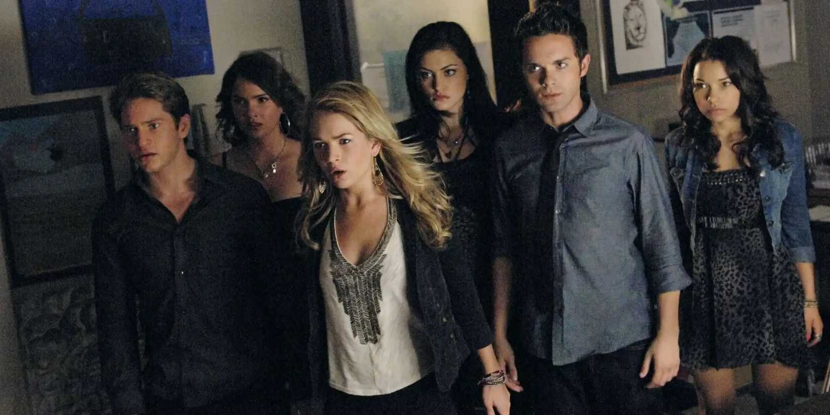 The cast of The Secret Circle stand in a group looking anxious.