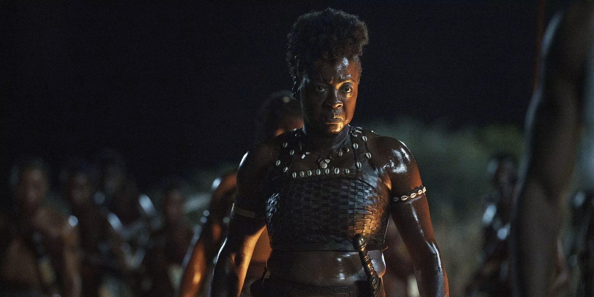 Nanisca standing proudly in an open field at night in 'The Woman King'