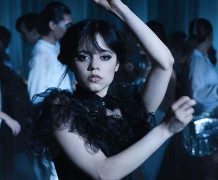 Jenna Ortega as Wednesday Addams dancing with her hands up in Wednesday.