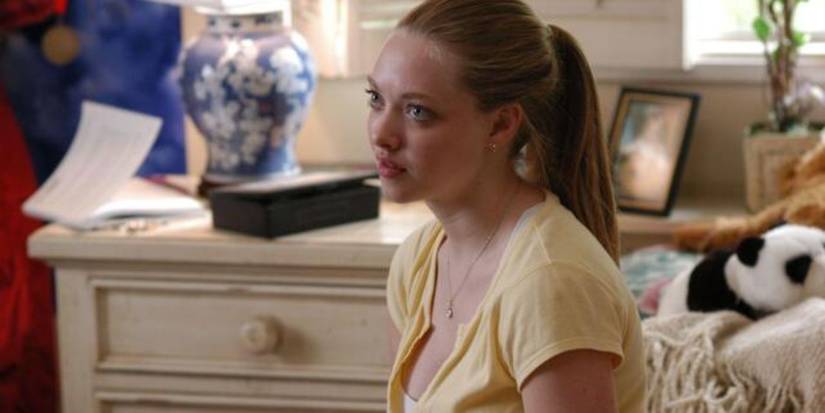 Amanda Seyfried sitting in a bedroom and looking at someone off-camera in Nine Lives.