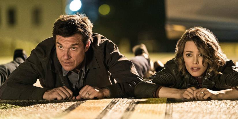 Jason Bateman and Rachel McAdams as Max and Annie, looking up while laying on the ground in Game Night.