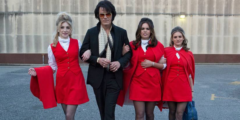 Elvis Pressley walking with four women in Elvis and Nixon