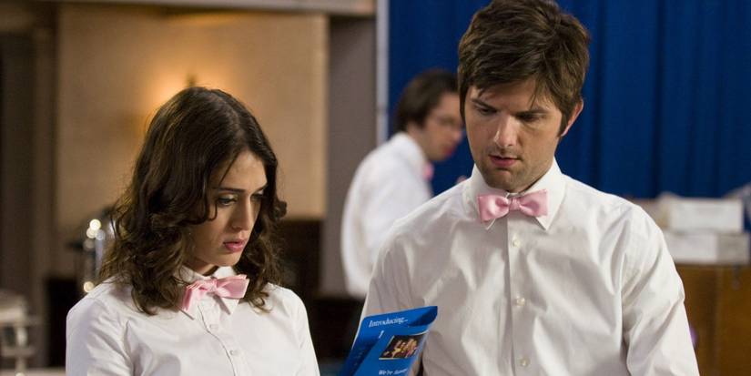 Lizzy Caplan and Adam Scott look at a brochure in 'Party Down'