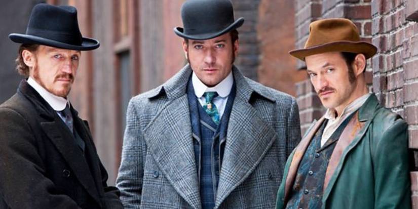 The cast of Ripper Street in period clothing look ahead at the camera with serious expressions.