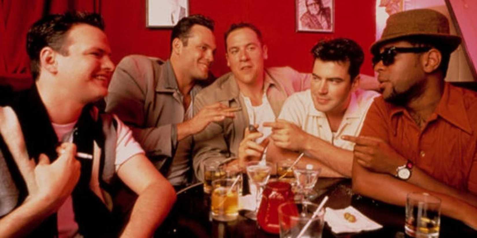 A group of male friends sit at a table holding several drinks at a party in Swingers (1996)