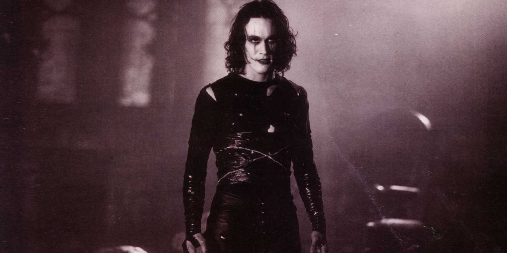 Brandon Lee as Eric Draven in the full black costume and white face makeup in The Crow.