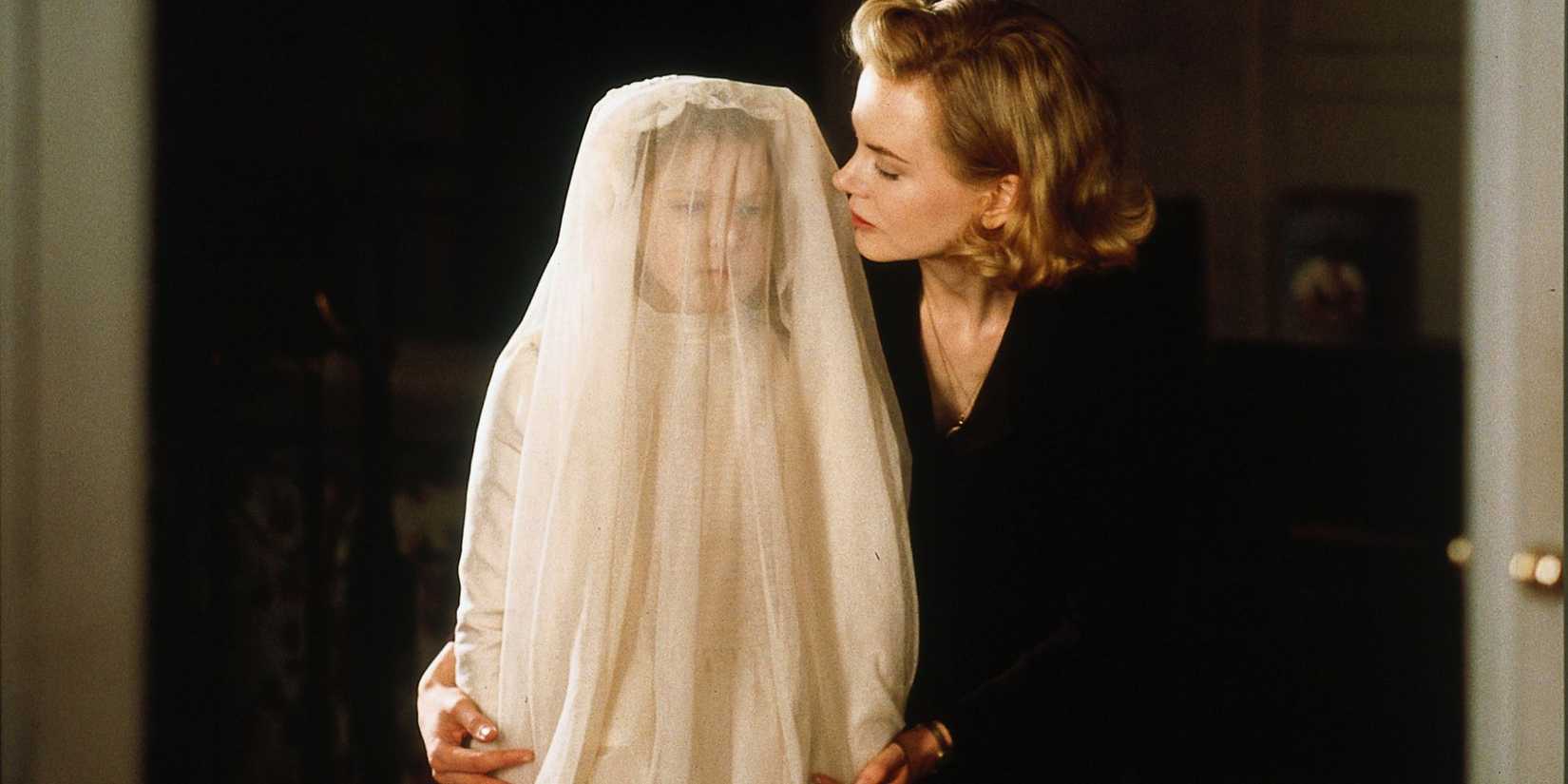 Nicole Kidman with a little girl covered in white in The Others.