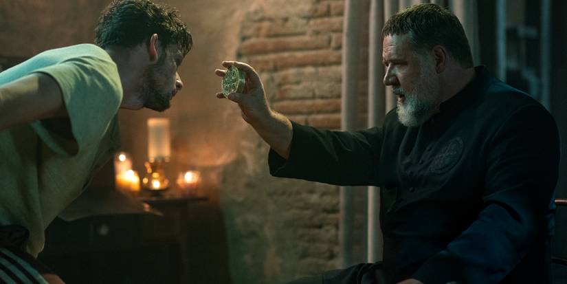 A priest (Russell Crowe) showing a religious relic to a possessed man in The Pope's Exorcist