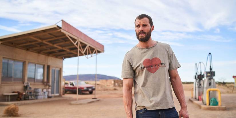 Jamie Dornan's "The Man" looking offscreen in a desert setting in The Tourist