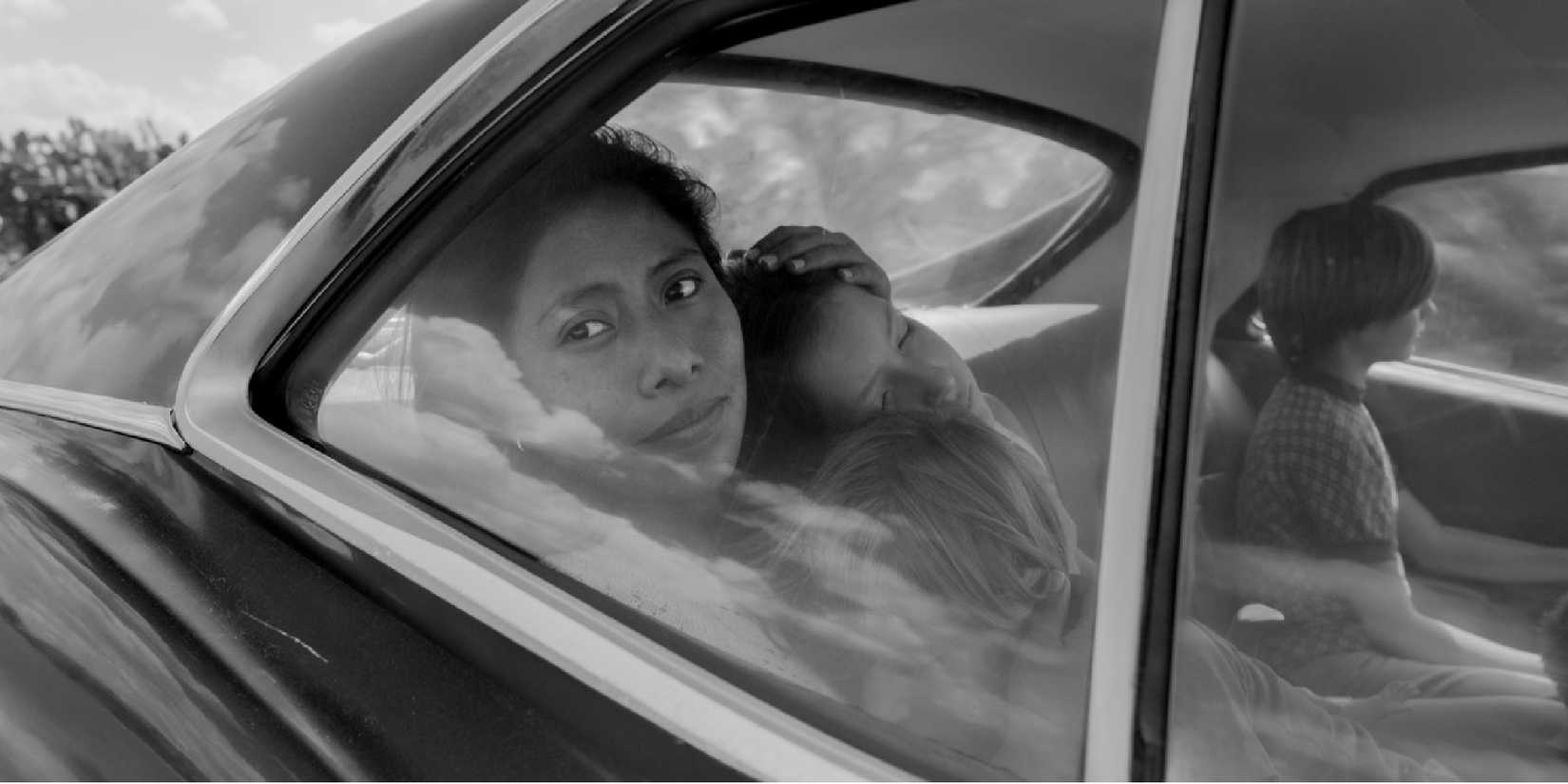 Yalitza Aparicio as Cleodegaria "Cleo" Gutiérrez, looking through a car window in 'Roma'