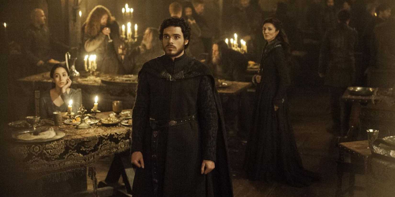Richard Madden as Robb Stark standing still and facing someone off-camera in Game of Thrones.